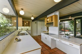 The kitchen is flooded with light on both sides, providing an open, airy flow. 