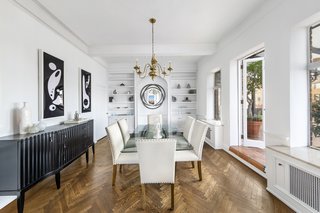 The light-filled dining room has an adjoining sunroom, which connects to a wraparound terrace.