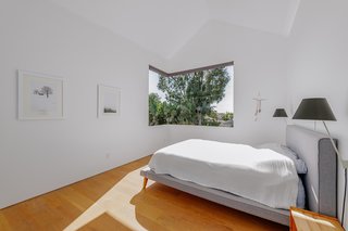 The master bedroom has a butt glass window and engineered white oak floors.