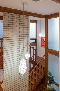 A double-height brick wall near the stairs adds midcentury charm.