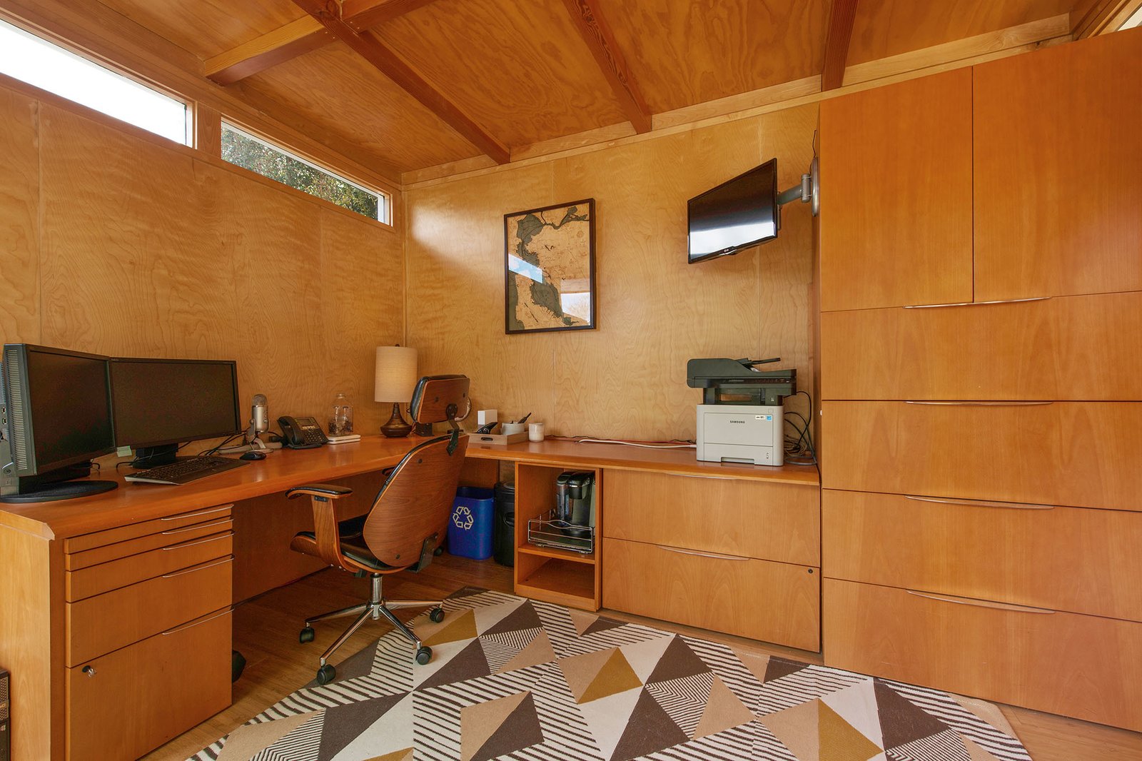 The studio is insulated, wired for electricity, and air conditioned. The wood-clad interior features a custom-built office system.