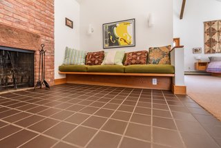 Built-in seating creates a cozy nook next to a brick fireplace.