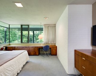 The master bedroom also features expansive glazing and built-in cabinetry. 