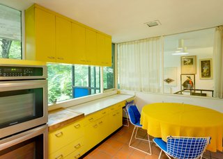 The kitchen features original, bright yellow St. Charles cabinetry.