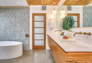 The stylish master bath is a mix of beautifully patterned porcelain tiles and wood.