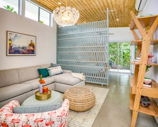 This bedroom has outdoor access and a sitting area with a divider screen that provides a sense of privacy without blocking light or breezes.
