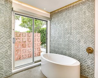 Even the bath has outdoor access. The tiles echo the pattern on the brise soleil.