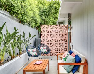 The small outdoor sitting area just outside the den features a striking brise soleil.