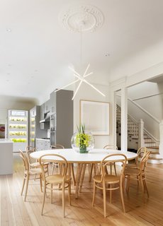 The dining room table seats 10 and features an integrated lazy Susan. It is crafted from white laminated plywood with Birdseye maple legs. Designed by Bohlin Cywinski Jackson architects and manufactured by Tomlinson Woodworks, it is available to purchase separately.