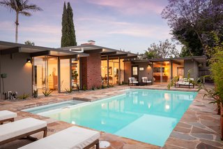 The pool takes up the majority of the L-shaped home's backyard.