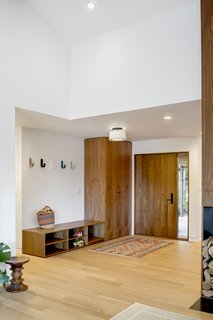 The entry features a walnut door and storage cabinets from Rejuvenation. The light fixture is from Cedar & Moss. 