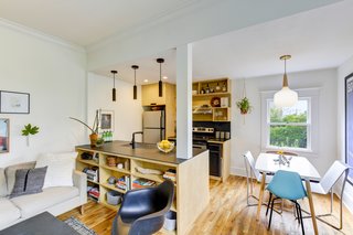 Adding built-in plywood bookshelves to the living room side of the kitchen island was a logical way to add storage and display space. Anderson also built a coffee table to match, using a remnant piece of blackened steel from his office, building a plywood box, and adding caster wheels.The pendant lights are simple matte black metal pipes that the couple ordered off Etsy from Greece. They also chose a Brizo matte black faucet to continue the "pipe look."
