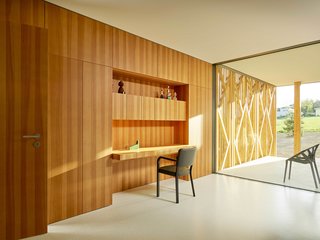 A wood-paneled, built-in desk nook is surrounded by cabinets. 