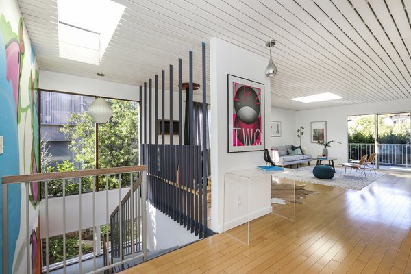The open floor plan benefits from lots of natural light thanks to multiple skylights, windows, and sliding glass doors that lead to a balcony.