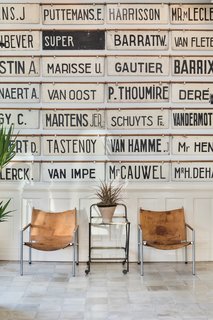 A wall of horse nameplates from a Belgian racetrack and white Egyptian tiles from the 1950s greet guests at the check-in area. 