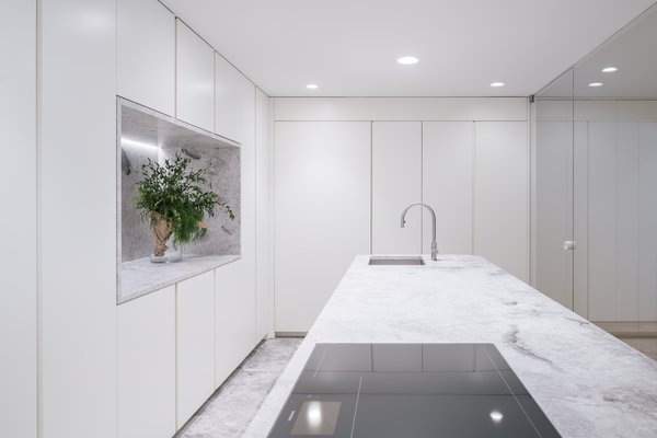 Ample, built-in storage lines the wall and the island. The appliances are from Gaggenau; the faucet from Cea Design.