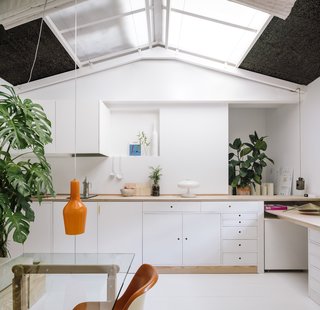 The former painting studio is now a multipurpose kitchen/dining/living/office space. Woodworking accounted for a major portion of the renovation budget—many of the furnishings were custom made using either pine or birch plywood (as seen in the countertop and office table).