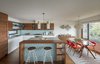 Modern home with Kitchen, Engineered Quartz Counter, Undermount Sink, Wood Cabinet, White Cabinet, Light Hardwood Floor, Pendant Lighting, Ceramic Tile Backsplashe, Refrigerator, Dishwasher, Range, and Microwave. A view into the airy, light-filled kitchen of 51 Nebraska by Todd Davis Architecture. The updated midcentury home pays homage to its roots. Photo of 51 Nebraska