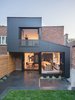 Modern home with Exterior, House Building Type, Brick Siding Material, Flat RoofLine, Metal Roof Material, and Metal Siding Material. Originally conceived as a jewel box that would evoke precious objects and fine woodworking, Architect Natalie Donne envisioned, “a box covered with smooth and black material on the outside and blonde wood on the inside.” Large sheets of lustrous black fibrocement were assembled using fine rivets to form two connecting prisms, complete with large opening glass walls. Photo of Black Box II