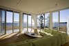 Modern home with Living Room, Sectional, Coffee Tables, Pendant Lighting, and Light Hardwood Floor. Folding glass NanaWall system in living room overlooking Atlantic Ocean Photo 2 of Mulberry Point House