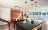Modern home with Doors, Exterior, Metal, Folding Door Type, and Wood. Kitchen island with pendant lighting, exposed exterior siding, cable railing, bamboo stairs, and NanaWall folding glass system Photo 11 of Houseboat H