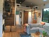 Modern home with Living Room, Medium Hardwood Floor, Sofa, Two-Sided Fireplace, Track Lighting, and Gas Burning Fireplace. Living room with storage loft, reclaimed wood accents, Chesterfield sofa, and Dutch door Photo 7 of Iki Hau'oli Hale (Tiny Happy Home)