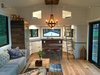 Modern home with Living Room, Sofa, Pendant Lighting, Track Lighting, and Light Hardwood Floor. Accordion stairs to hidden guest loft, opening glass NanaWall system Photo 8 of Iki Hau'oli Hale (Tiny Happy Home)