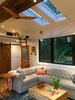 Modern home with Living Room, Light Hardwood Floor, Two-Sided Fireplace, Track Lighting, Sofa, Recessed Lighting, and Gas Burning Fireplace. Automatic skylights, reclaimed wood beam, Chesterfield sofa, blue rug, barn door, fan, and Dutch door Photo 12 of Iki Hau'oli Hale (Tiny Happy Home)