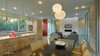 Modern home with Engineered Quartz Counter, Wood Cabinet, Concrete Floor, Ceiling Lighting, Pendant Lighting, Accent Lighting, Undermount Sink, Dishwasher, Sofa, Gas Burning Fireplace, Coffee Tables, Standard Layout Fireplace, Dining Room, Chair, Table, Bar, and Stools. View Toward Entry Photo 9 of The Graphic House