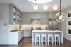 An overall photo of the kitchen with the Bernd and Hilla Becher photograph series on the right. The drum skylight can be seen above and in the foreground are branches of a Lindsey Adelman pendant which hangs over the dining table. Photo 2 of White Street Residence modern home