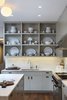 A detail photo of the kitchen - when we were designing this our client had the special request that we add open display shelving for her amazing collection of vintage ironstone. This photo also shows the careful alignment of the lighting fixtures with the cabinetry. Here the tape-in recessed fixtures are on axis with the passageway between the island and back counter which is centered on the vertical upright of the shelving. These alignments, while subtle,are part of the overal layering which we feel adds calmness to the space Photo 14 of White Street Residence modern home