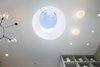 Looking up into the 5' wide drum skylight in the White Street Residence - remote controlled synchronized linear actuators open and close the skylight which allowed us to meet the NYC Code for legal light and air. A beautiful Lindsey Adelman Branch chandelier is on the left and Flos Glo Ball fixtures paired with USAI Bevel trimless fixtures are on the right. Photo 16 of White Street Residence modern home