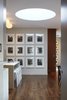 This photo shows the transition between the entry hallway and the kitchen & dining areas. The drum skylight in the ceiling above illuminates the space with natural daylight. Photo 19 of White Street Residence modern home