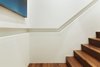 A detail photo of the inset handrail. The lower panels and handrail are fabricated from Glacier White Corian - above the handrail is skim coated drywall painted to match. The handrail runs continuously from the lower floor to the penthouse. Photo 8 of White Street Residence modern home