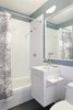 A side view of the Corian vanity with fold-up shelf. There is a routed pull that allows you to gain purchase to raise the shelf. The GFCI outlet, located in the niche, is accessed when in the up position & when not in use the shelf folds down and nests into the niche allowing it to sit flush with the vanity side. Photo 16 of Riverside Residence modern home