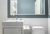 Space is at a premium in NYC bathrooms. To maximize this space we created a concealed fold-up shelf as part of this custom Corian vanity. This gives the owner an extra shelf on which to place items when needed but easily folds down to help keep an open feel to the room. Photo 17 of Riverside Residence modern home