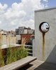The garden is accessed from a rooftop penthouse designed by pulltab and built two years earlier. A large diameter steel pipe was cut and placed into a new stucco wall. This aperture frames a view to a power plant located on the Lower East Side. The steel ring was left unpainted so it can rust and bleed down the wall. The floating bench is made from Cor-Ten steel and teak which is left to weather a beautiful grey. Photo of East Village Roof Garden modern home