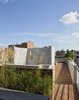A view from the entry to the roof deck toward the outdoor shower. The shower wall has an opening which frames the New York Life Insurance Building which can be seen in the distance. Photo 2 of East Village Roof Garden modern home