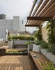 Modern home with Outdoor, Rooftop, Raised Planters, Gardens, Walkways, Shrubs, Small Patio, Porch, Deck, Wood Patio, Porch, Deck, and Decking Patio, Porch, Deck. A view looking south toward the penthouse addition. The pergola is planted with wisteria providing a welcoming shade. Photo 10 of East Village Roof Garden