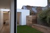 The master bedroom and bathroom can be viewed across the courtyard from the galley kitchen that occupies the glazed link. Photo of Unité de Rénovation modern home
