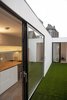 Reflections in the glazed doors and mirrored kitchen spash-back create the illusion of layers of space beyond. Photo 5 of Unité de Rénovation modern home