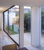 The dining area is open-plan to the kitchen and living space and separated from the courtyard by large panels of fixed glazing. Photo 8 of Unité de Rénovation modern home