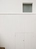 A frameless sand-blasted window provides light to the ground-floor shower room, which is sited above a timber-clad outdoor storage enclosure. Photo 2 of Periscope modern home