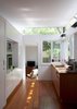 Looking from the open-plan dining area, through the kitchen to to the new living space, one gets views of the tree canopy through a high-level band of frameless glazing. Photo of Villa Leichhardt modern home