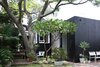 The original building is treated with a black paint finish to set up a visual relationship with the black glass and stained timber of the modern addition. Photo 8 of Villa Leichhardt modern home