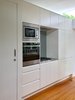 A white pod stops short of the full ceiling height, incorporating kitchen appliances and storage, and accommodating the bathroom. Photo 6 of Villa Leichhardt modern home
