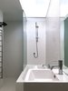 Inside the white pod, the white-tiled bathroom is top-lit by a glazed panel bringing in borrowed natural light from the high-level glazing in the kitchen. Photo 7 of Villa Leichhardt modern home