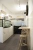 From the entry, visitors see the white and black marble sculptural volumes of the service counter and preparation areas, and the plywood lights and tables. Photo of Storefront for Cake and Architecture modern home