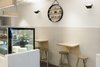 Tiles to the walls and vinyl to the floor are both continuous between the customer and staff areas, further blurring the boundary between the two and heightening the sense of involvement in the baking process. Photo 2 of Storefront for Cake and Architecture modern home