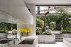 Modern home with Kitchen, White Cabinet, Mirror Backsplashe, Ceramic Tile Floor, and Undermount Sink. The brutalist council estate to the rear is viewed as a found-object artwork through a new cast-concrete and stark white frame. Photo of Soupçon Brut